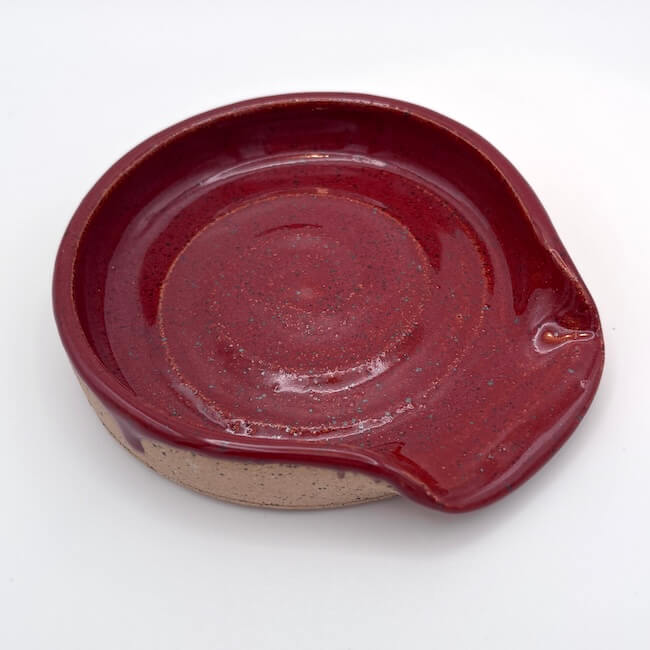 Ceramic dish with a red-brown glaze on a white background
